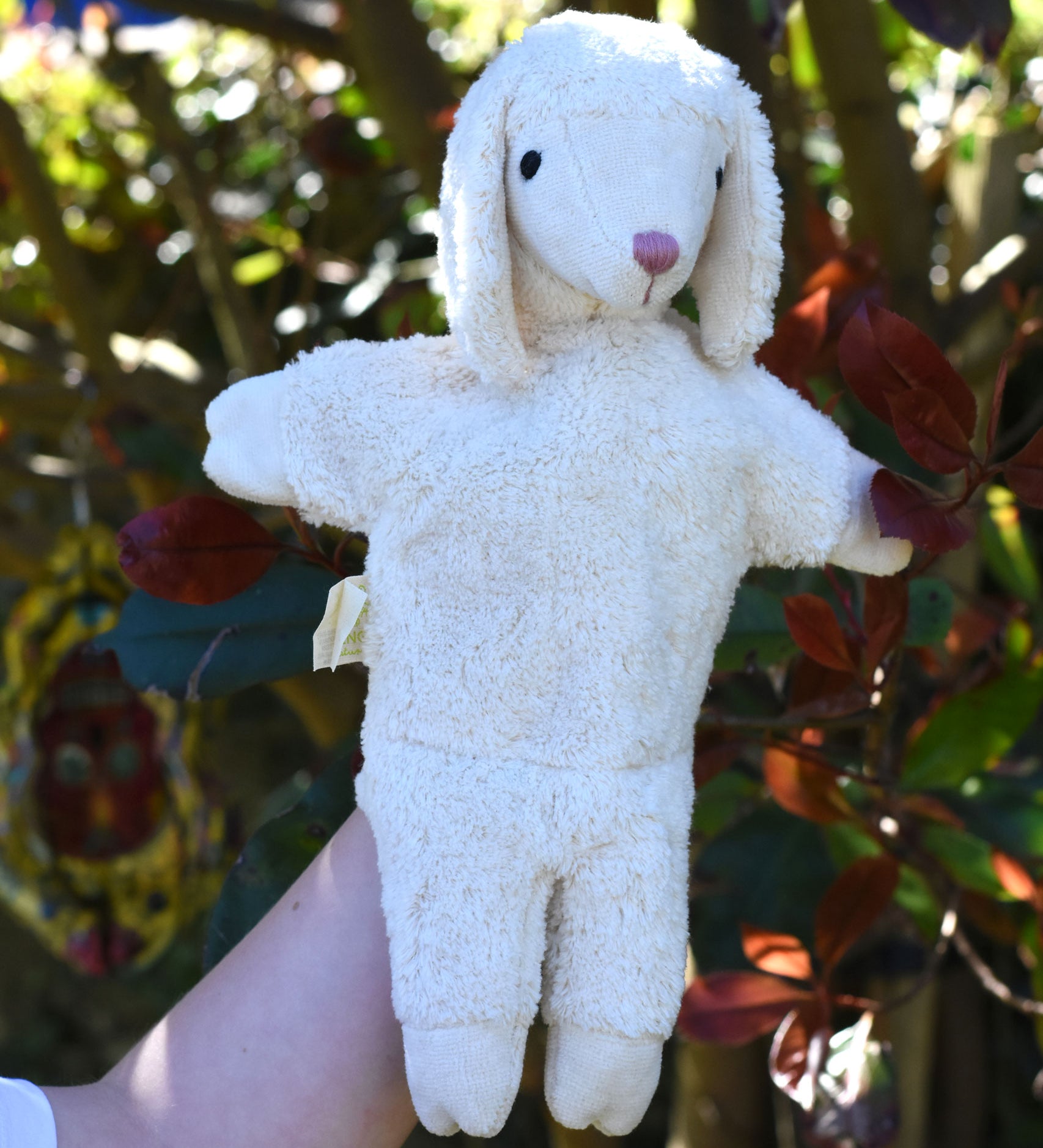 A Senger white sheep organic cotton puppet in use on a child's hand.