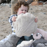 A child holding up a large Senger cuddly animal soft toy in front of them.