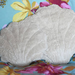 A large and small Senger shell cuddly animal soft toy placed on a colourful floral pattered bed sheet.