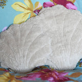 A large and small Senger shell cuddly animal soft toy placed on a colourful floral pattered bed sheet.