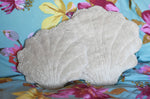 A large and small Senger shell cuddly animal soft toy placed on a colourful floral pattered bed sheet.