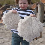 A child holding up a large and small Senger cuddly shell toy. 