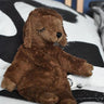 A Senger small brown cuddly sheep organic soft toy placed on a black and white monochrome patterned duvet. The small brown sheep is part of Senger's cuddly range of soft toys available at Babipur.  