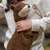 Child holding to a small GOTS organic cotton brown Senger otter cuddly toy