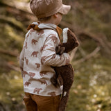 Child holding to a small brown Senger otter cuddly toy in a forest