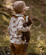 Child holding to a small brown Senger otter cuddly toy in a forest