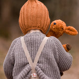 Back of child with a Senger small brown cuddly deer toy looking over the shoulder