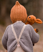 Back of child with a Senger small brown cuddly deer toy looking over the shoulder