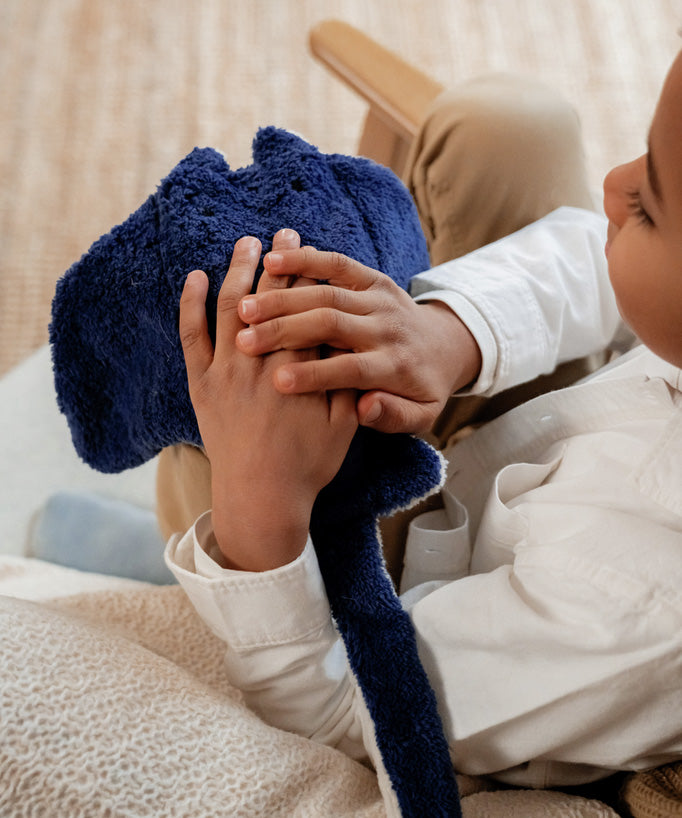 A child holding the Senger organic cotton stuffed manta ray toy