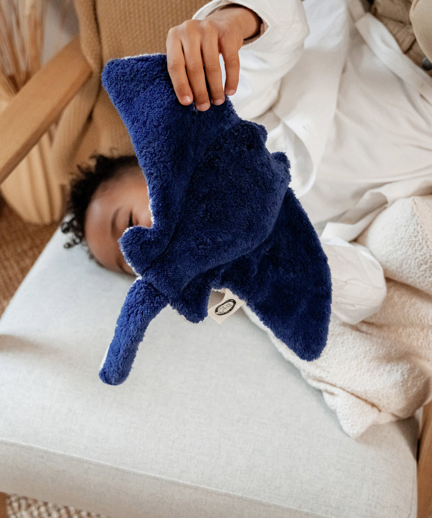 The Senger small cuddly manta Ray stuffed organic toy, being held by a toddler