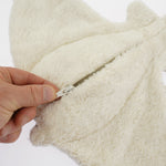 The under side of the Senger organic cotton small manta ray stuffed cuddly toy, with a hand opening the zip