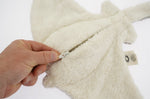 The under side of the Senger organic cotton small manta ray stuffed cuddly toy, with a hand opening the zip