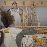 A small cuddly Senger seagull soft toy resting on a basket with blankets