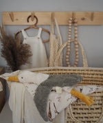 A small cuddly Senger seagull soft toy resting on a basket with blankets
