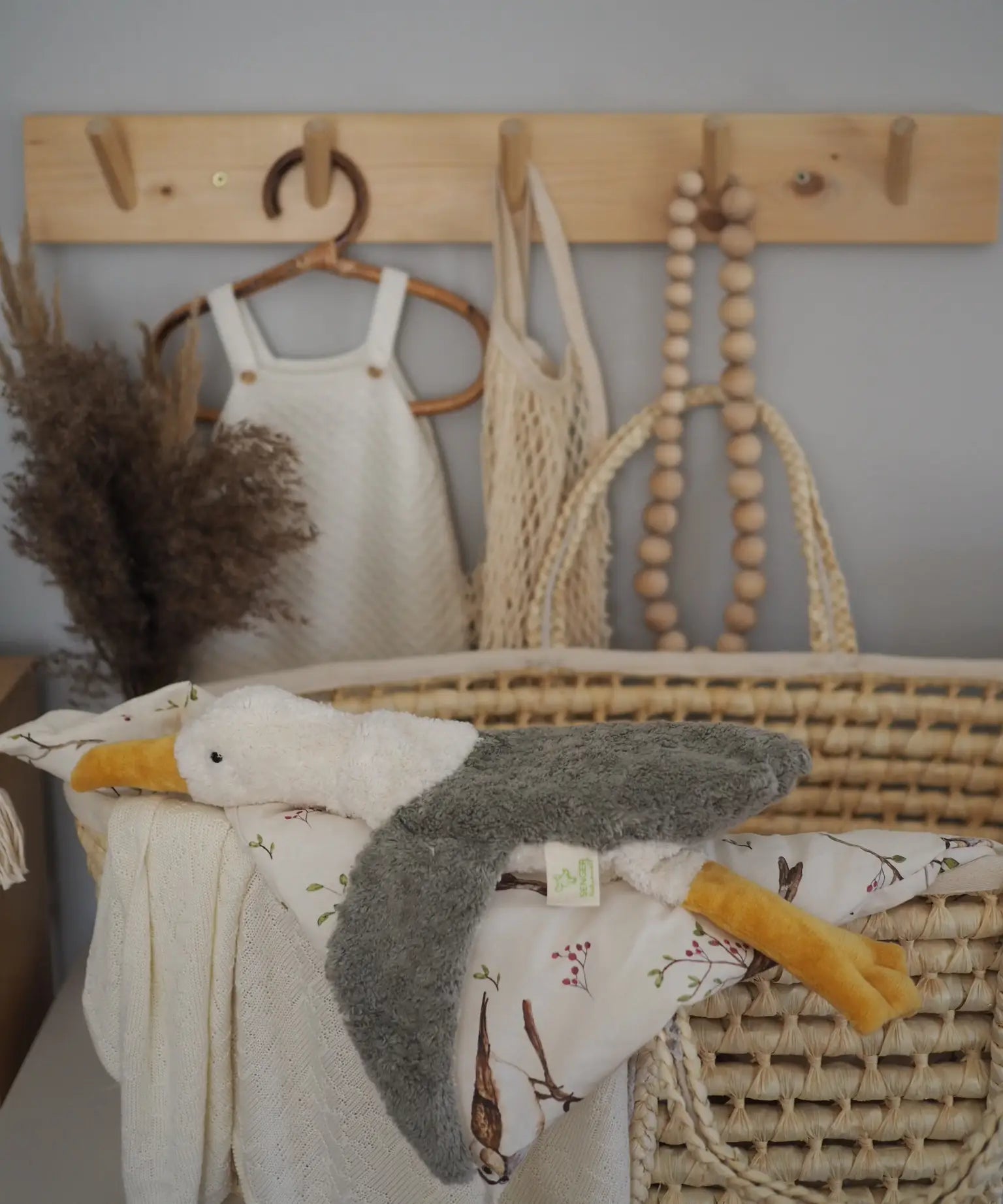 A small cuddly Senger seagull soft toy resting on a basket with blankets