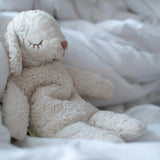 Senger GOTS organic cotton small cuddly white sheep toy sitting on against a blanket