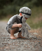 A small child bent down, playing with the Senger organic cotton stuffed floppy donkey toy. 