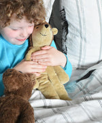 A child cuddling the Senger small floppy hedgehog, the child has both his hands wrapped around the organic soft toy. The hedgehog is part of a wider selection of soft toys made with organic cotton and natural fillings that are available at Babipur. 