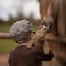 A child holding up  Senger Small Floppy Horse on their shoulder.