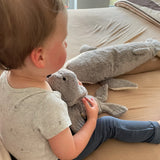 Child sitting with a small Senger grey seal cuddly toy on their knees