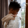 Child with a Senger GOTS organic cotton small cream cuddly goose soft toy over their shoulder 