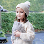 A little girl holding her Senger organic cotton heatable cuddly grey manta ray stuffed toy