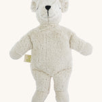A small soft cuddly white Senger polar bear toy on a cream background. 