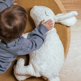 Child placing a hand on the Senger large white cuddly rabbit soft toy. Organic cotton outer with natural sheep's wool and spelt chaff filling.