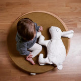 Child sitting on a wobbel 360 with deck with a Senger large white cuddly rabbit soft toy. 