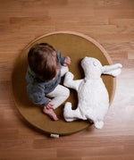 Child sitting on a wobbel 360 with deck with a Senger large white cuddly rabbit soft toy. 