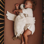 child hugging senger white goose while sleeping