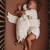 child hugging senger white goose while sleeping
