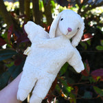 A Senger white sheep organic cotton puppet in use on a child's hand.