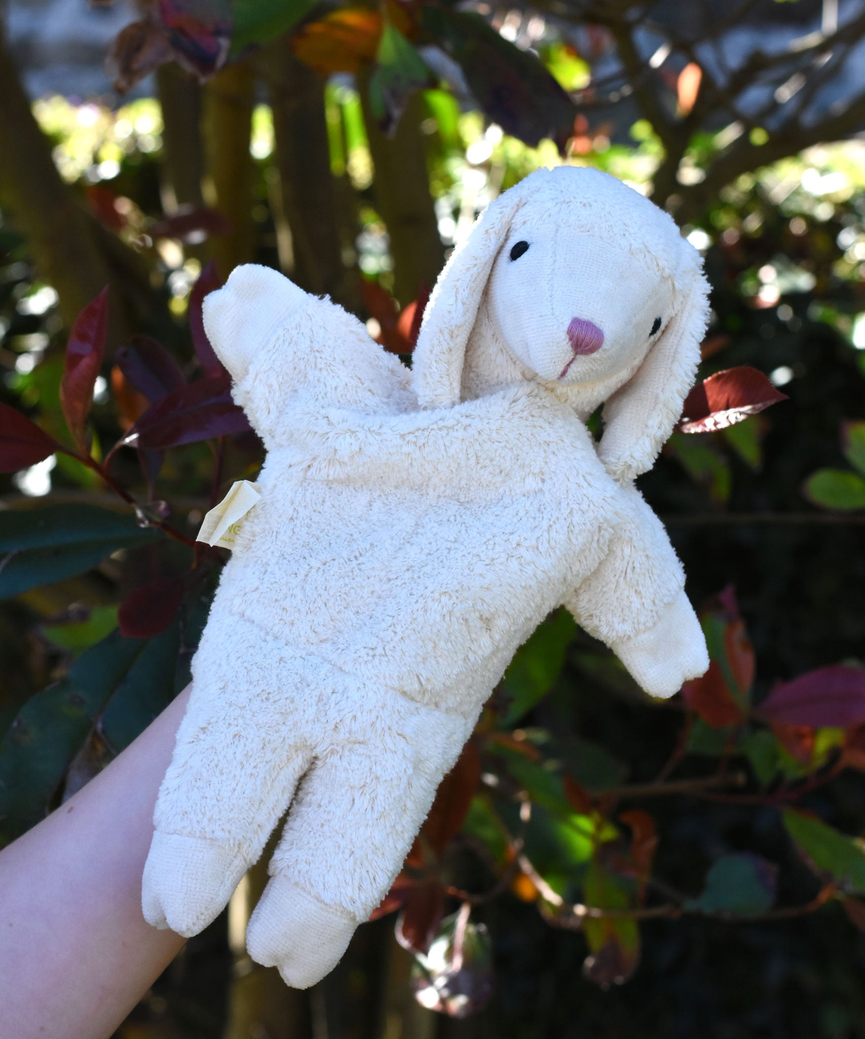A Senger white sheep organic cotton puppet in use on a child's hand.