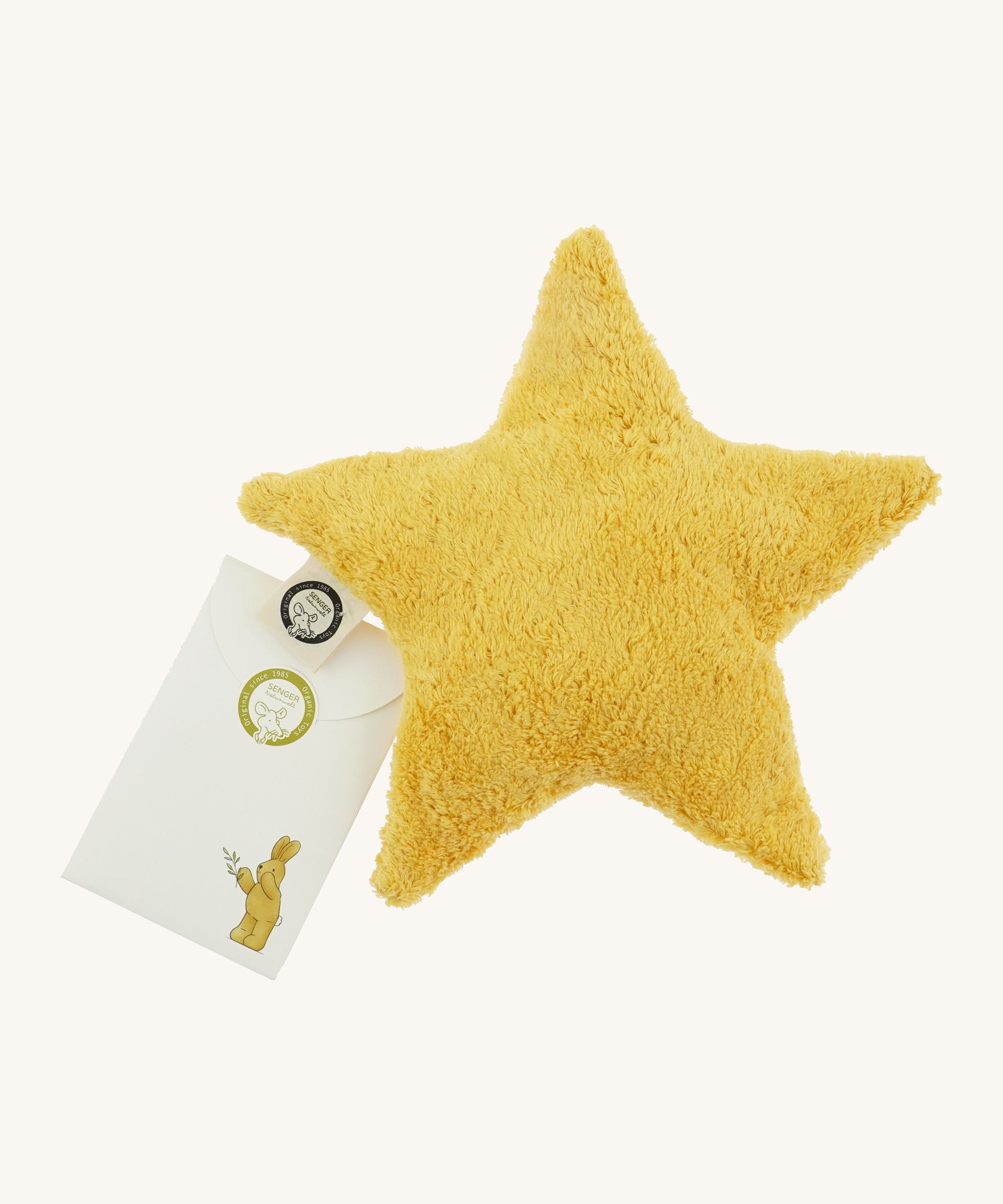 Senger warming star cushion. A yellow fluffy GOTS organic cotton cushion that can be warmed up with a small gift pouch attached to the label