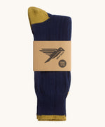 Silverstick Caburn Organic Cotton Socks in the Adriatico navy colour way. Shown folded and placed in the cardboard sleeve packaging.