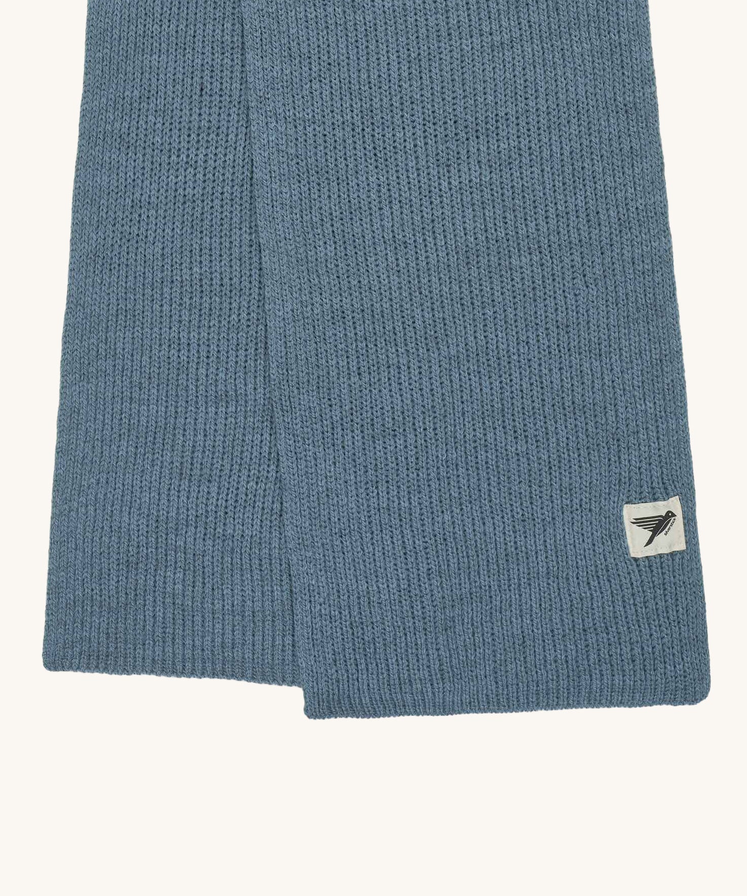 A close up of the logo label on the Silverstick Cirrus Merino Wool Scarf in a Celeste blue colour. Silverstick are proudly made in the UK and stocked here at Babipur. 