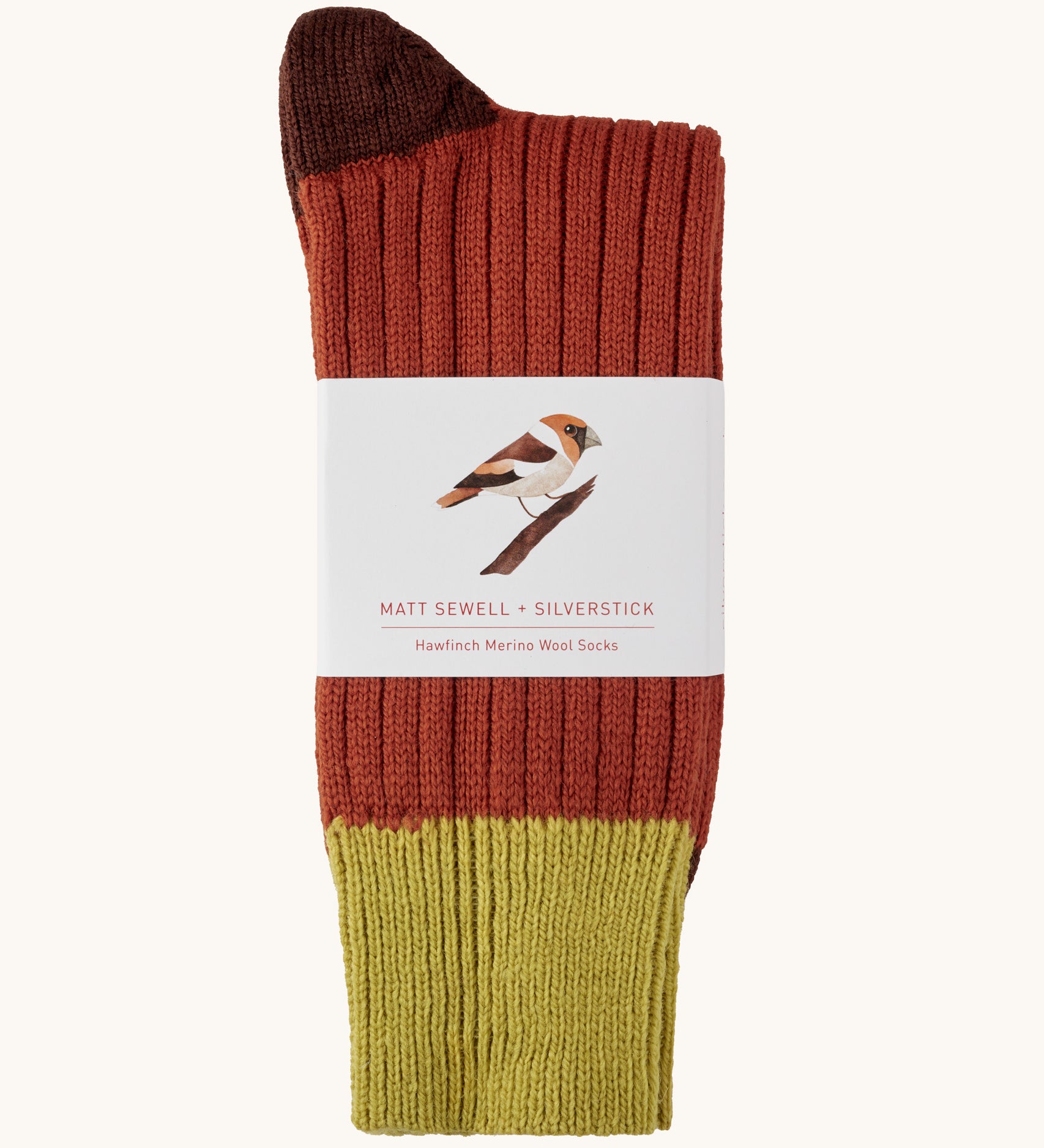 Silverstick Matt Sewell Hawfinch Merino Socks shown folded over and placed into their paper packaging sleeve. 