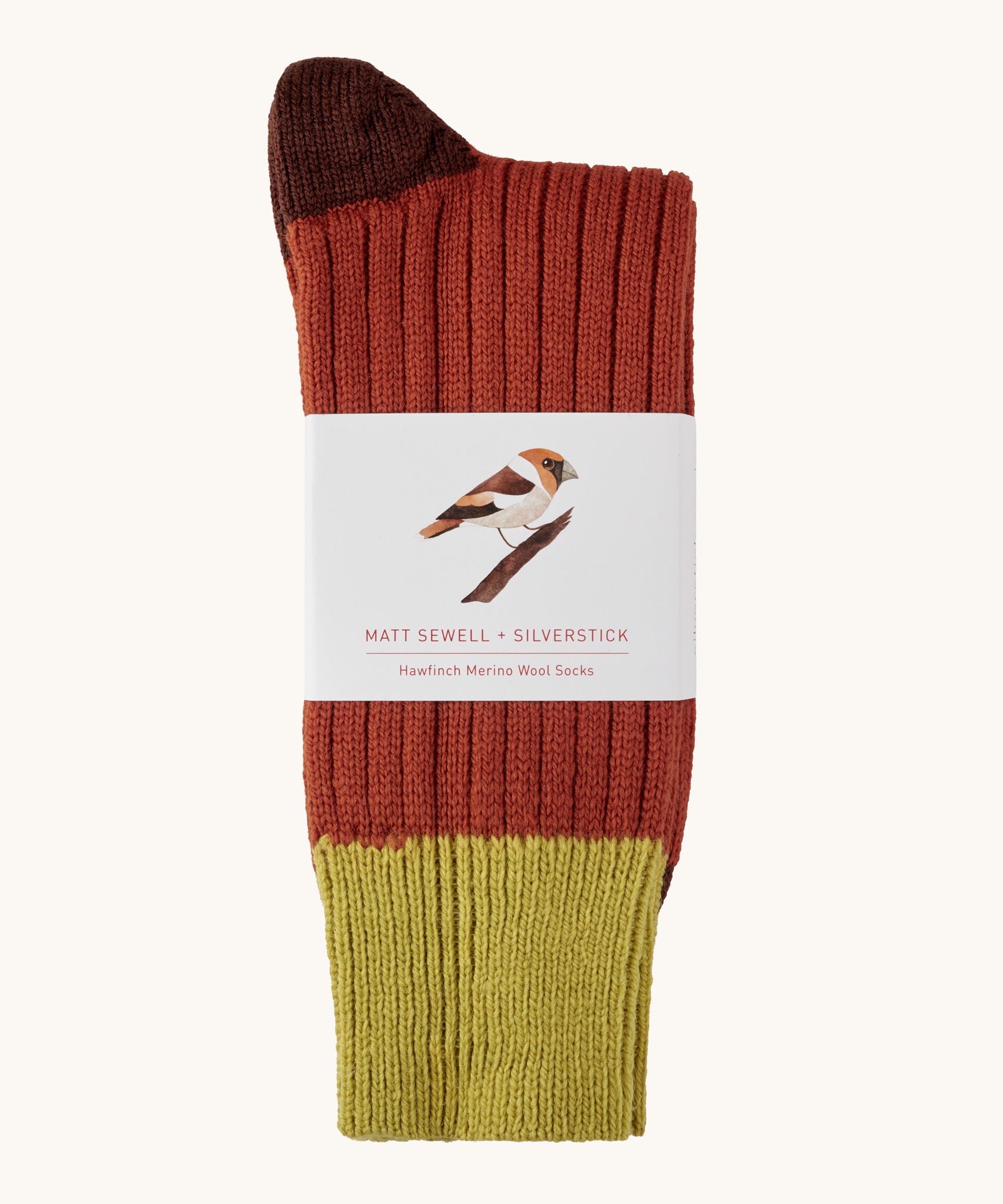Silverstick Matt Sewell Hawfinch Merino Socks shown folded over and placed into their paper packaging sleeve. 