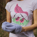 A close up of a woman wearing the Silverstick Matt Sewell Curlew Organic T-Shirt in a Lilac colour way.