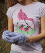 A close up of a woman wearing the Silverstick Matt Sewell Curlew Organic T-Shirt in a Lilac colour way.