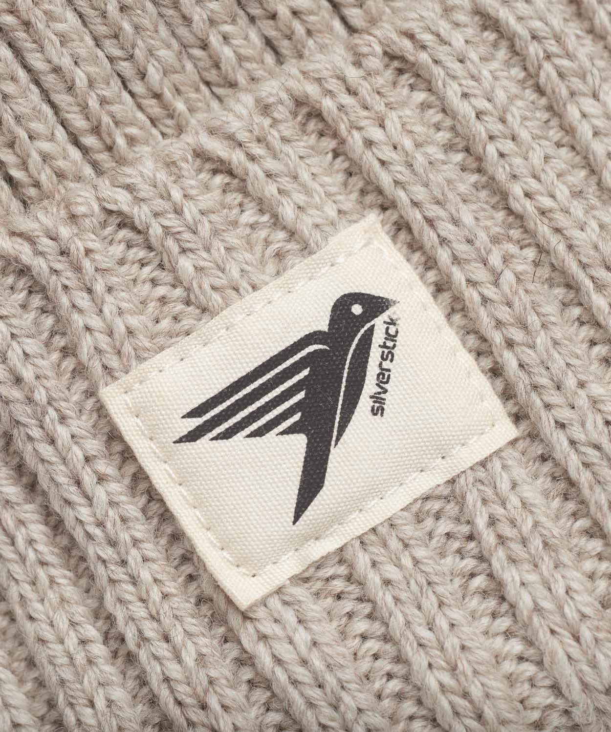 A close up of the label on the Silverstick Moffat Merino Wool Beanie in the Oat colourway. Silverstick are proudly made in the UK and available at Babipur. 