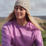 A woman on a hike, wearing the Silverstick Moffat Merino Wool beanie hat in a cream colour to keep naturally warm.