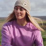 A woman on a hike, wearing the Silverstick Moffat Merino Wool beanie hat in a cream colour to keep naturally warm.