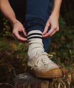 A close up of a person wearing a Silverstick Organic Cotton Air sports Sock with off white colured canvas shoes.