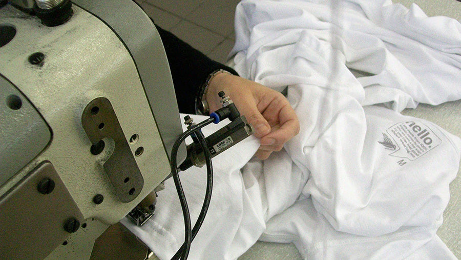 A closeup of somebody using a sewing machine to make an organic cotton Silverstick t-shirt