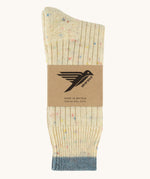 The Silverstick Pennine Wool Socks in the rainbow nepp colourway shown folded over and placed in their cardboard packaging sleeve. 
