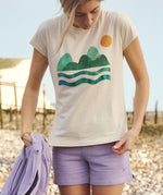 A woman wearing the Silverstick Habitats Organic T-Shirt in the Angora colourway.