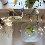 Reusable Mint Leaf Swedish sponge cloths being washed and dried around a kitchen sink for repeated use in a plastic-free home.