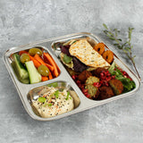 A Slice Of Green Stainless Steel Divided Plate. The plate has hummus in the smallest section, carrot, cucumber and olives in the middle section and flatbread, salad and falafels in the biggest section. This stainless steel plate is suitable for snacks and meals and perfect for children and adults. 